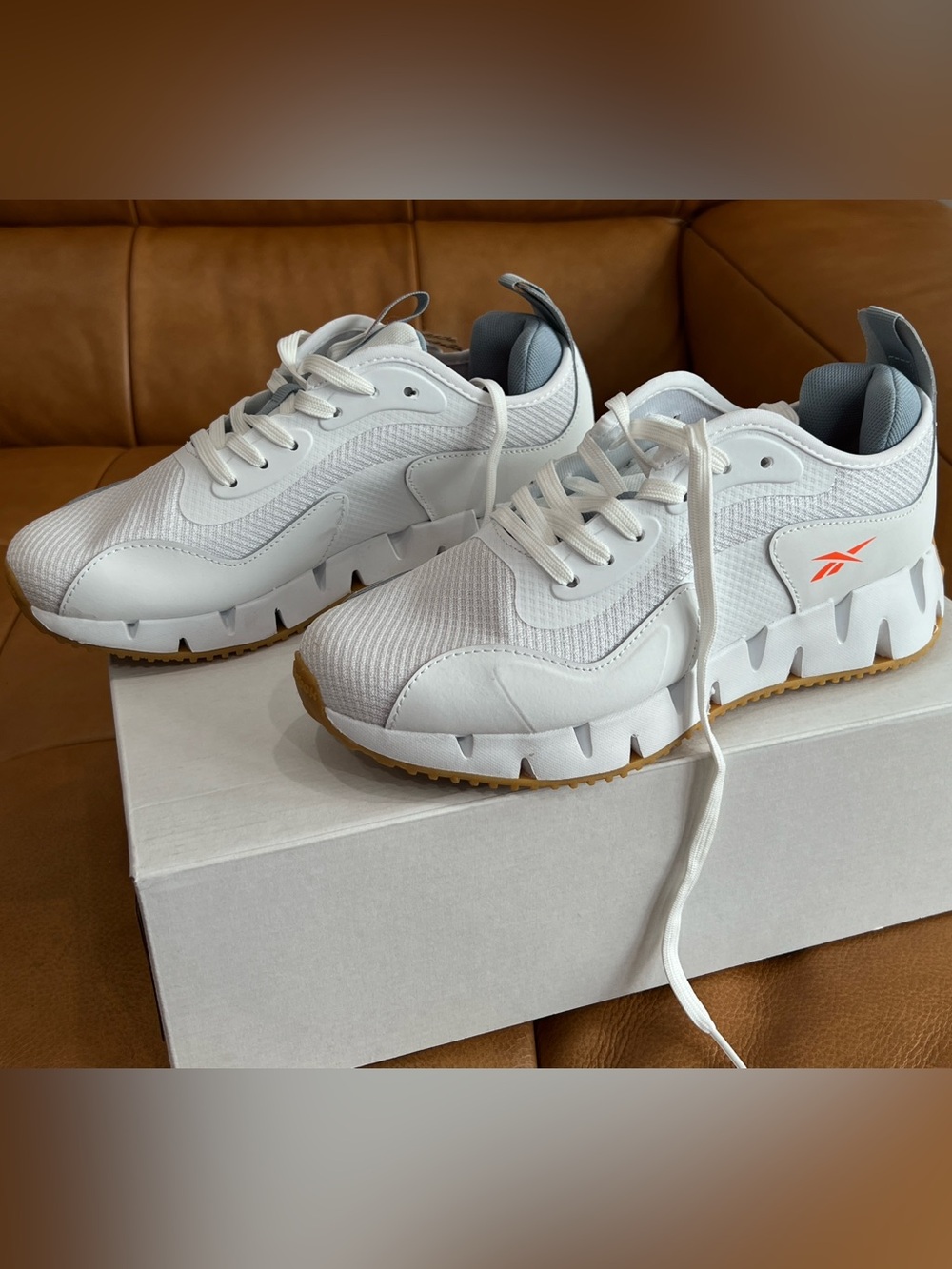 Reebok Women’s White on White Zig Dynamica G Sneakers With Orange Reebok Symbol